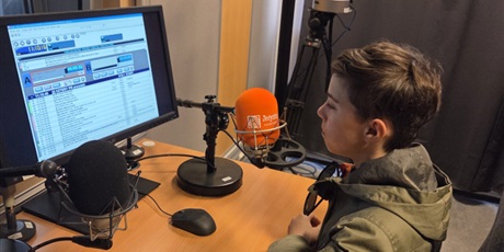 Powiększ grafikę: Chłopiec prowadzący program radiowy w studiu nagrań