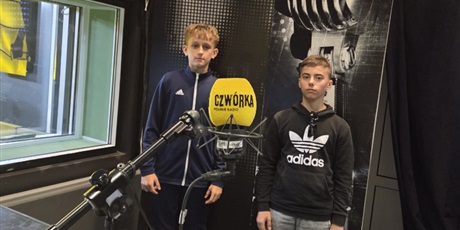 Powiększ grafikę: Dwóch chłopców w studiu nagrań radiowej Czwórki na tle obrazu mikrofonu