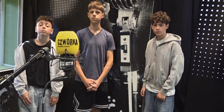 Powiększ grafikę: Trzech chłopców w studiu nagrań radiowej Czwórki na tle obrazu mikrofonu