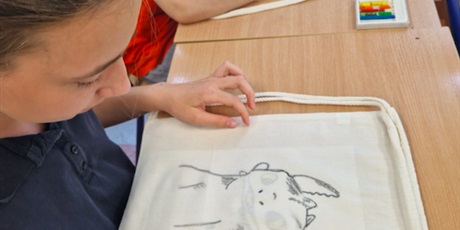 Powiększ grafikę: Dwie dziewczynki wypełniają kolorem kontur obrazka na lnianym plecaku