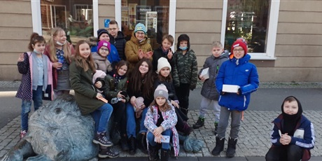 Powiększ grafikę: Szesnaścioro dzieci z uśmiechami na twarzy siedzi na gdańskim lwie, który znajduje się na Starym Mieście
