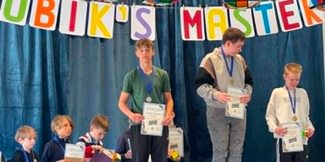 Powiększ grafikę: 6 chłopcy stoją na podium 1, 2 i 3 miejsce wcale duże kostki Rubika