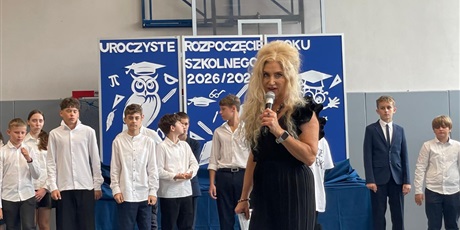 Powiększ grafikę: Pani Dyrektor przemawia do zgromadzonych, za nią uczniowie ubrani na galowo