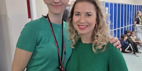 Powiększ grafikę: Dwie panie ubrane na zielono uśmiechają się stojąc obok siebie