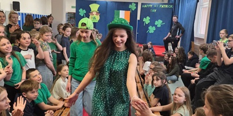 Powiększ grafikę:  Dwie dziewczynki ubrane na zielono idą po czerwonym dywanie