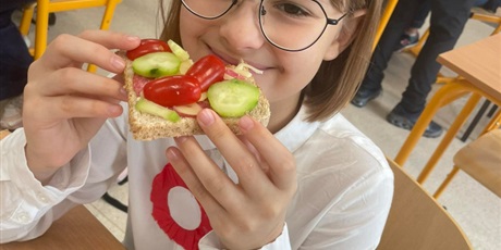 Powiększ grafikę: Uśmiechnięta dziewczynka jeżdżąca pyszna zdrowa z warzywami kanapkę