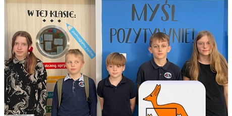 Powiększ grafikę: 5 uczniów stoją na tle niebieskiej ściany z napisem Myśl pozytywnie oraz Matematyka jest miarą wszystkiego. W prawym dolnym roku obrazek z kangurem