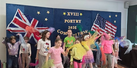 Powiększ grafikę: Grupa dzieci kolorowo ubranych ze wstążkami tańczy w układzie tanecznym