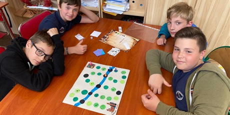 Powiększ grafikę: Chłopcy grają w grę stworzoną przez koleżanki z klasy. Jeden z nich ma uniesiony kciuk. 