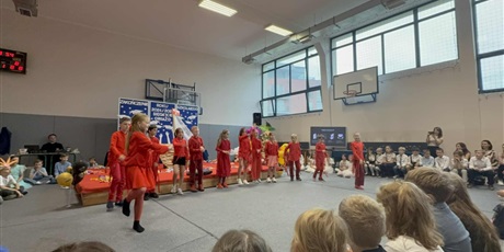 Powiększ grafikę: Grupa dzieci w czerwonych strojach w tańcu do utworu "Na drodze tej"