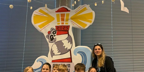 Powiększ grafikę: Nauczycielka z uczniami pozuje przy makiecie latarni morskiej