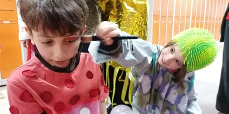 Powiększ grafikę: Dziewczynka robi koledze makijaż na scenę