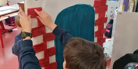 Powiększ grafikę: Chłopiec dokleja cegiełki do makiety