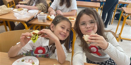 Powiększ grafikę: Uśmiechnięte dwie dziewczynki jedzące pyszne zdrów kanapki
